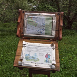 Austrått, Austråttlunden, the grove of Austrått, a information board against a green background