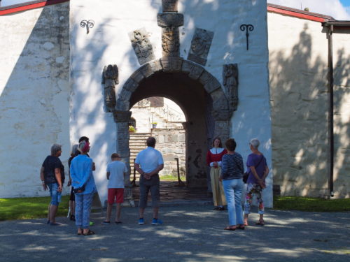 Austrått Manor, Austråttborgen, some people are waiting outside the gate of a manor, sunny weather