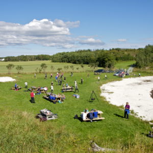 Austrått, Stor-Jektvika, Austrått agrotourism, several youths in activivty on a beach, some kayaks to the right, sunny weather