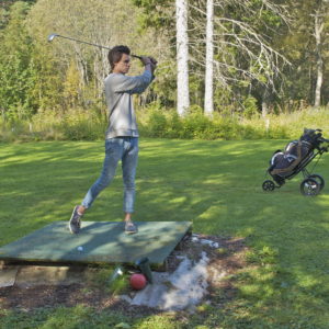 Austrått Golf course, Ørland, Austrått agrotourism, young man looking after the golf ball after a shot,