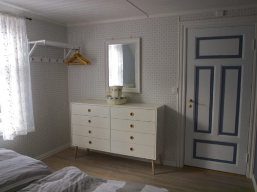 Holiday house, Austrått agrotourism, Kårstua, bedroom with blue and white colours, white commode and a mirror above.