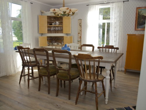 Austrått agrotourism, Kårstua, dining room, big brown dining table with white legs, corner cabinet, furniture in a nostalgic style