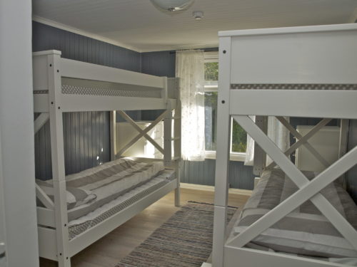 Holiday house, Austrått agrotourism, Kårstua, bedroom with two white bunk beds, blue walls, blå vegger, rugs on the floor, window in the background