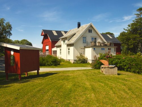 Ørland, Austrått, Austrått agrotourism, white house in the centre, red barn behind, sunny and blue sky